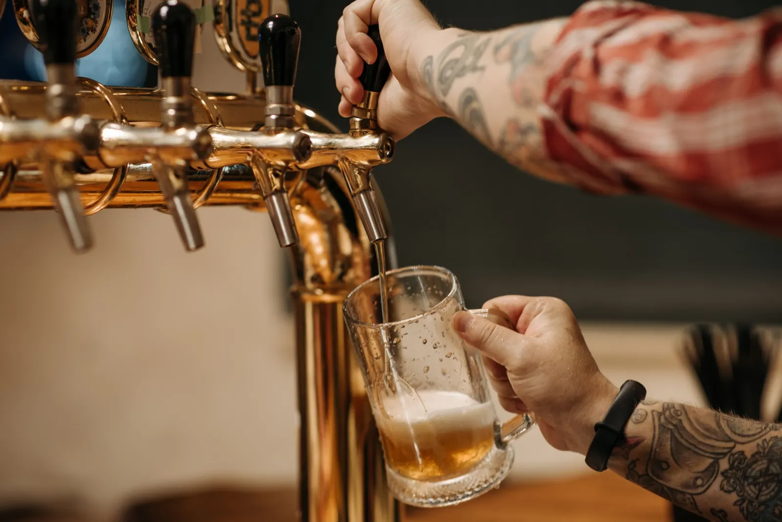 Birra che scende da una spina in ottone dentro un boccale di vetro